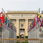 View of the United Nations Office in Geneva adorned with flags of various countries.