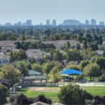 Aerial view of Sacramento suburb with skyline in the distance, showcasing residential and urban contrast.