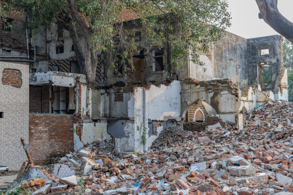 A crumbling heritage structure in Delhi surrounded by debris, showcasing urban decay.