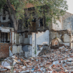 A crumbling heritage structure in Delhi surrounded by debris, showcasing urban decay.