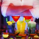Colorful cocktails with citrus slices on a bar, perfect for nightlife settings.