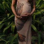 Expectant mother embracing nature in a lush green garden.