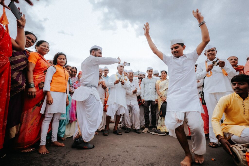 A vibrant Indian street dance with a group of people celebrating in traditional attire outdoors.