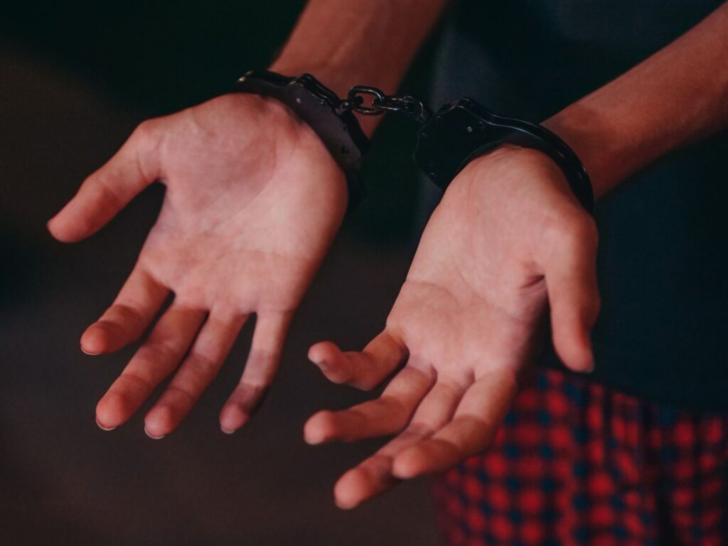 A close-up image showing hands in handcuffs, symbolizing justice and law enforcement.