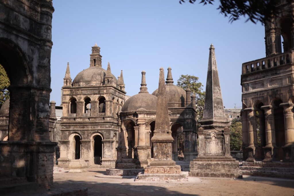 Explore ancient architectural structures in a sunlit historical cemetery, showcasing rich heritage.