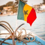 Colorful Senegalese flag and nautical ropes on a boat deck, perfect for travel themes.