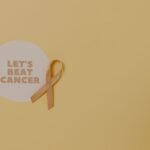 Minimalist design featuring a ribbon and 'Let's Beat Cancer' message for cancer awareness.