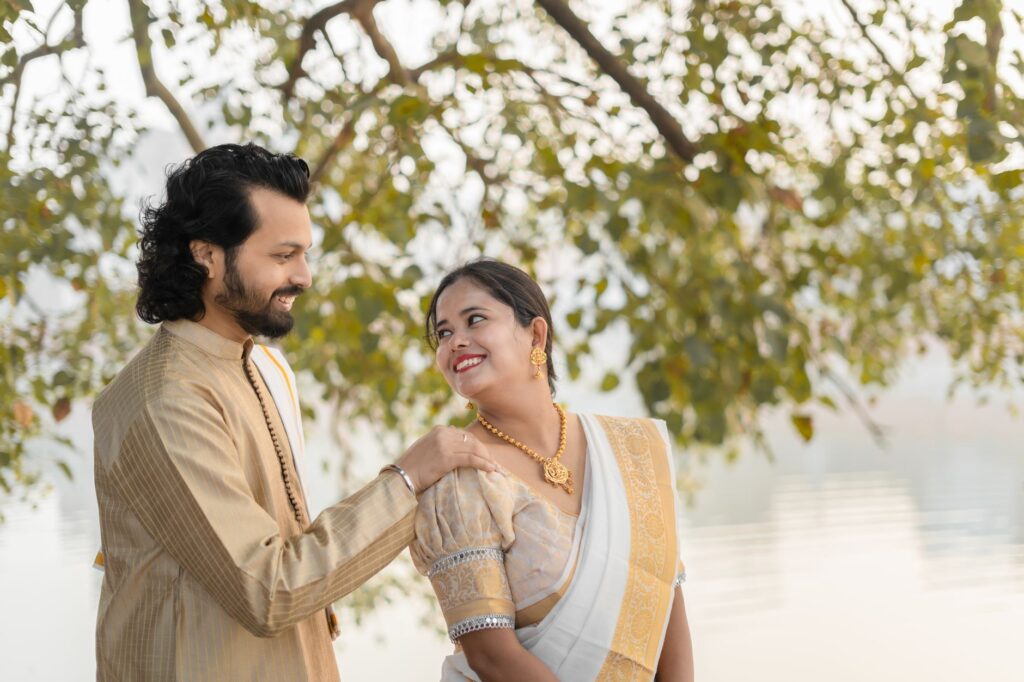 Beautiful Indian couple in traditional attire enjoying a romantic moment outdoors.