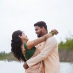 Indian couple joyfully embracing near a water body, exuding happiness and connection.
