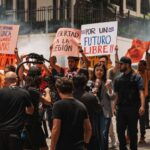 Journalists cover a protest rally for freedom in San José, Costa Rica. Demonstrators hold signs demanding liberty.