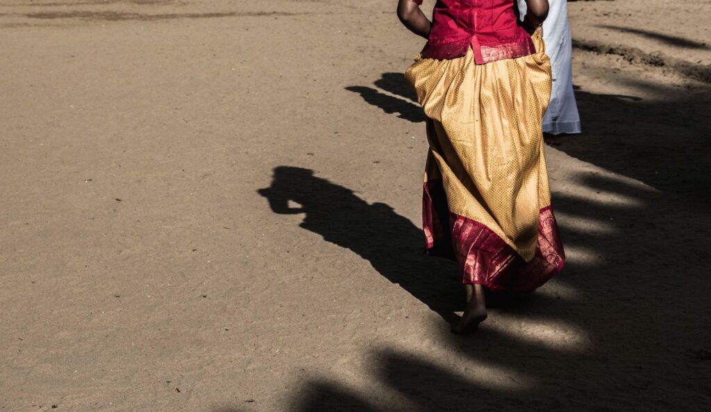 Traditional attire in Jaffna, Sri Lanka, casting artistic shadows on a sunny day.