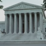 Front view of the iconic Supreme Court building with classical columns and majestic architecture.