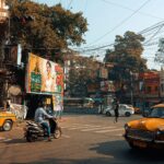 Vibrant street life in Kolkata featuring iconic yellow taxis and historic architecture.