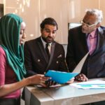 A multicultural business team discussing documents in a contemporary office setting.
