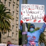 A woman participates in a protest against obstetric violence in Mexico City, holding a powerful sign.