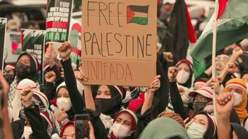 Protesters in Jakarta holding placards supporting Palestine. Social activism and unity.