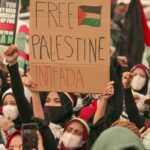 Protesters in Jakarta holding placards supporting Palestine. Social activism and unity.