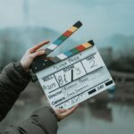 Close-up of a film clapperboard on an outdoor set, signaling scene start.