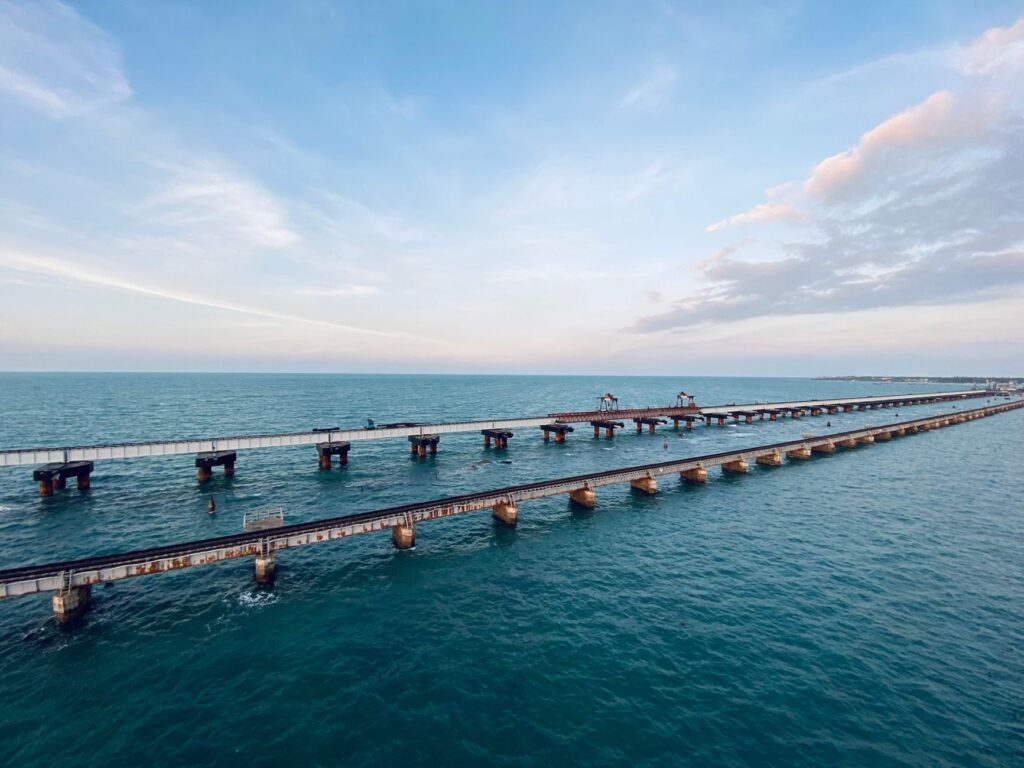 Aerial shot of the iconic Pamban Bridge over the blue waters of Rameswaram, India.