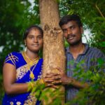 South Asian couple in traditional attire embracing a tree, symbolizing love and nature.