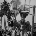 Dynamic black-and-white outdoor basketball game showcasing athleticism in Los Angeles.