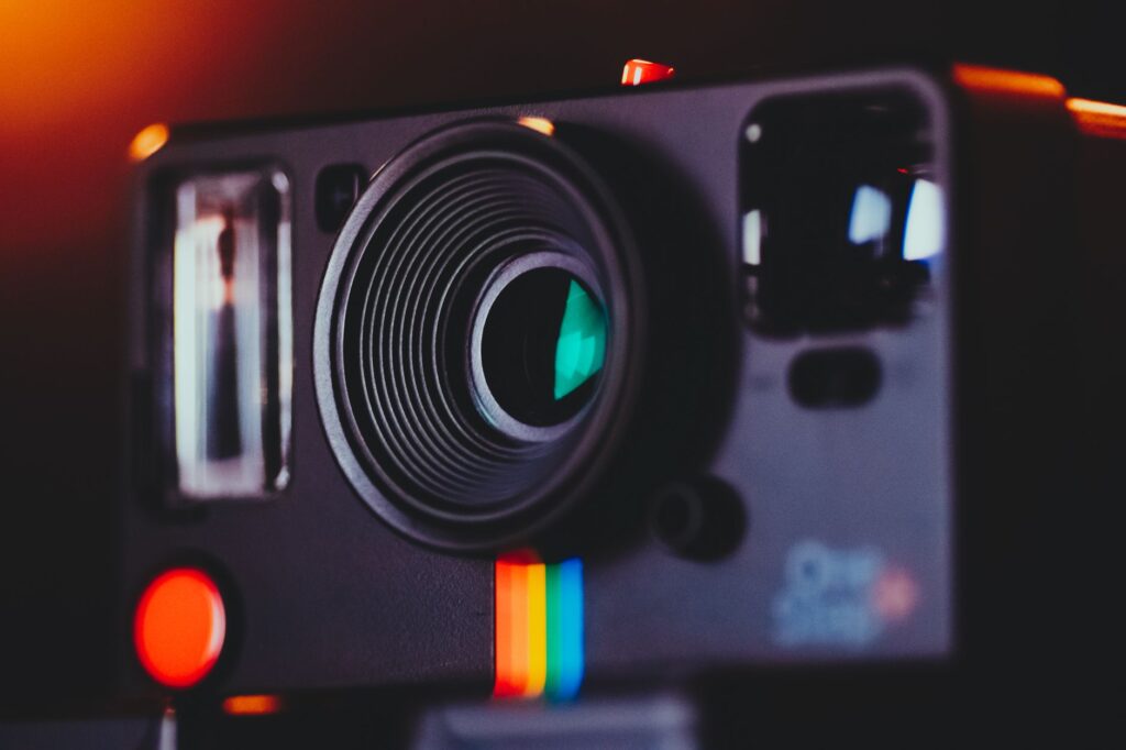 Artistic close-up shot of a vintage instant camera lens with colorful accents.