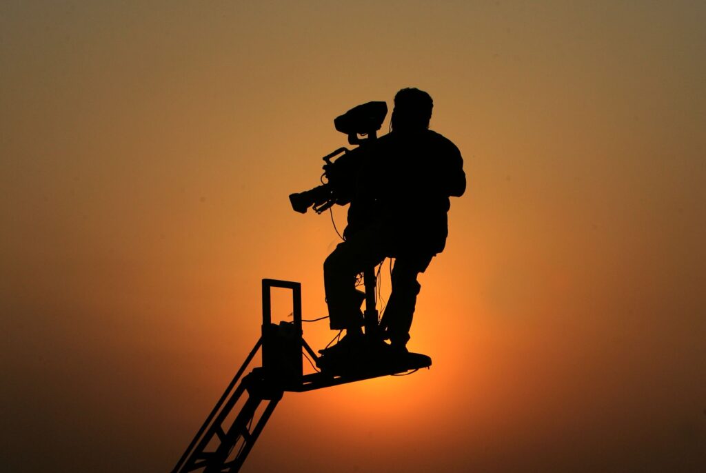 Silhouette of a cameraman capturing footage against a sunset in Lahore, Pakistan.