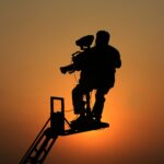 Silhouette of a cameraman capturing footage against a sunset in Lahore, Pakistan.