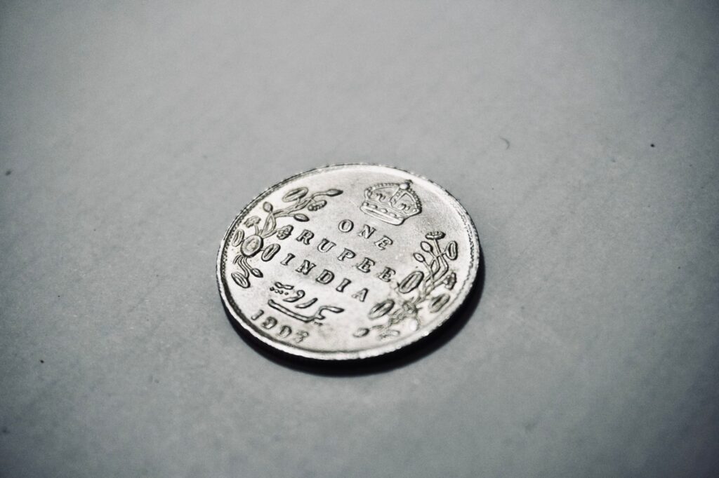 Close-up photograph of a 1907 silver Indian rupee coin with intricate details.
