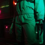 A cyberpunk setting featuring a person with a robotic arm amidst neon and retro elements.