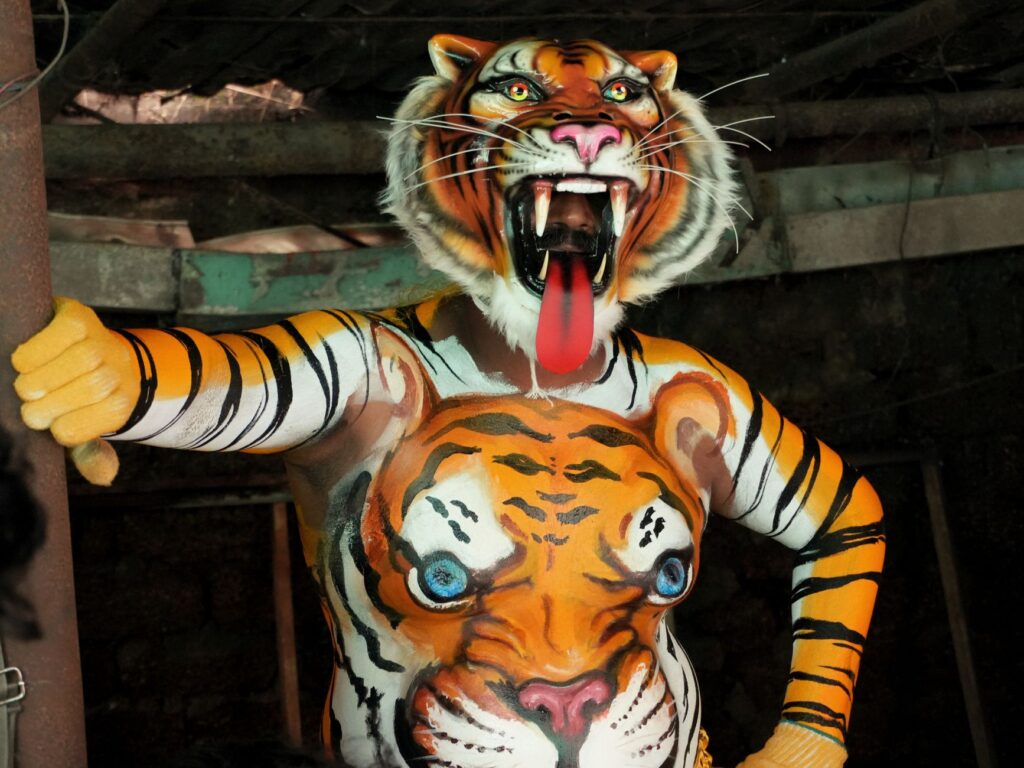 Vibrant costume of Pulikali tiger dance performer during Kerala's Thrissur festival.