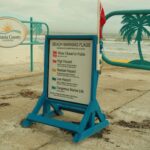 Beach warning flags sign in Volusia County, Florida, indicating hazard levels near public beach.