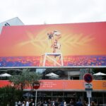 Large billboard at the Cannes Film Festival showcasing vibrant imagery.