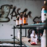 Discover an abandoned industrial room featuring shelves of toxic chemical bottles and graffiti walls.
