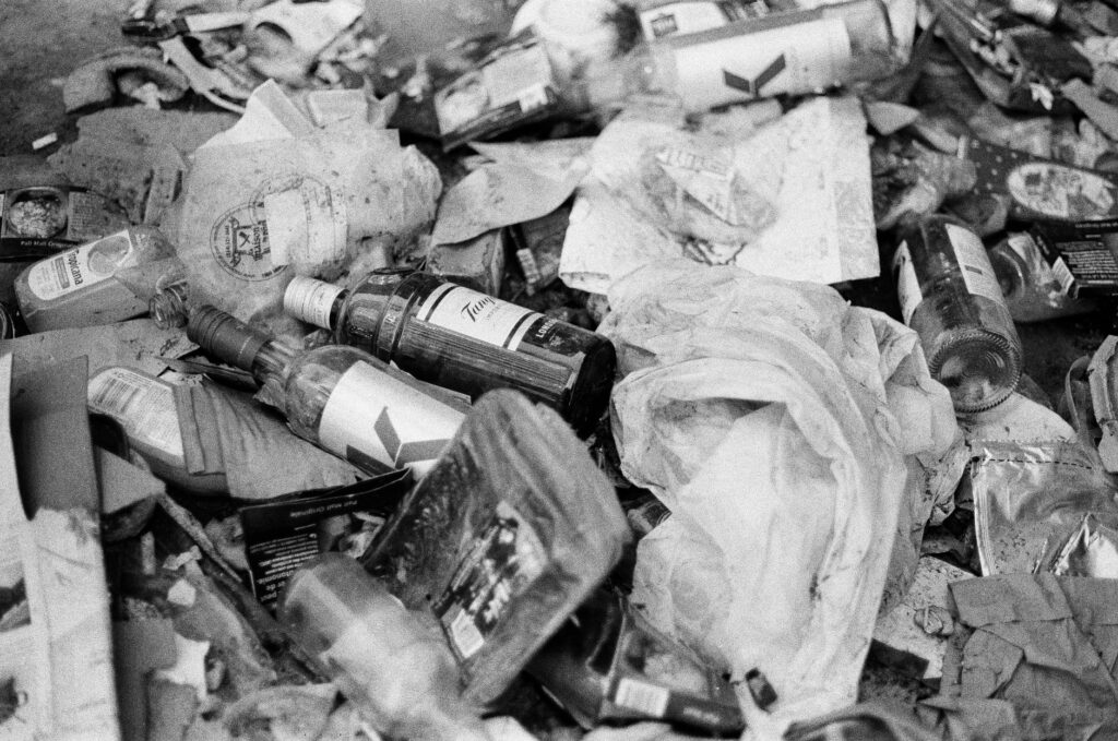 Monochrome photo showcasing littered bottles and trash highlighting pollution.