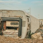 A derailed train lies overturned on a barren track, showcasing a scene of destruction.
