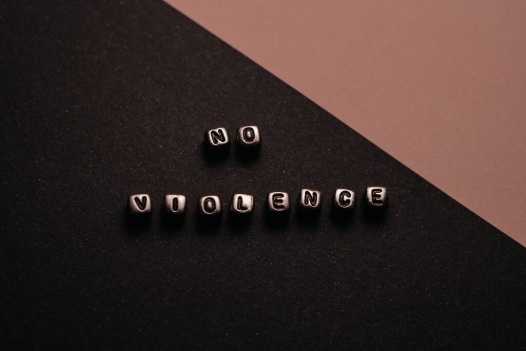 Artistic composition with text cubes spelling 'No Violence' on a two-tone background.