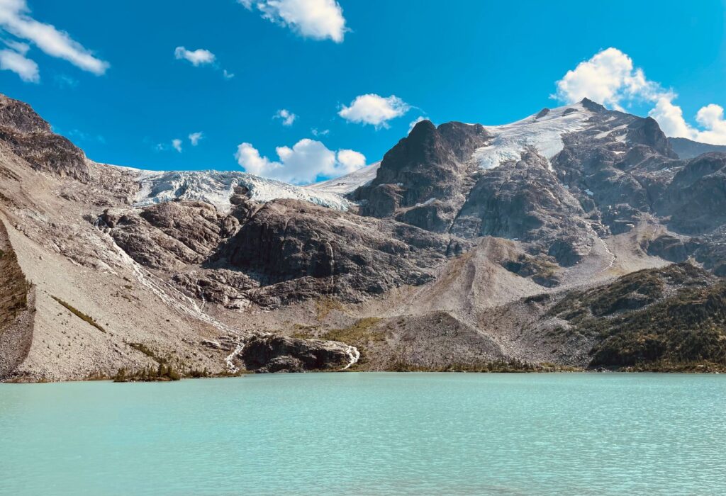 Stunning view of a turquoise glacier lake with majestic mountains at Mount Currie, Canada.