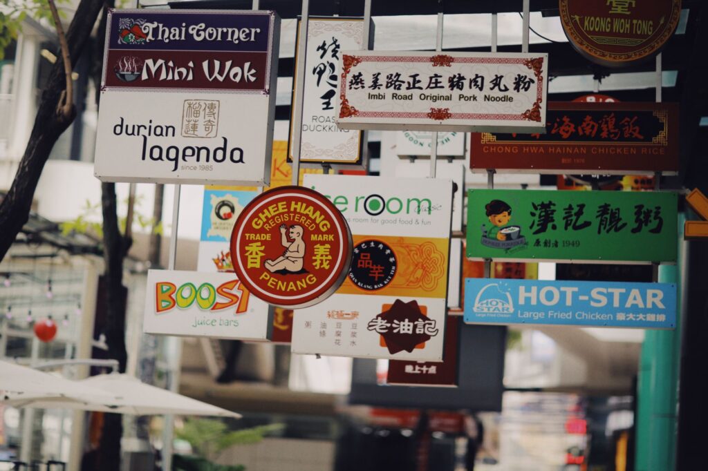 Colorful mix of multilingual signs in a busy Asian street, showcasing diverse cuisines and cultures.