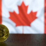 Golden Bitcoin coin displayed in front of a blurred Canadian flag symbolizing cryptocurrency in Canada.