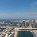 A breathtaking aerial view of Dubai Marina and Palm Jumeirah with modern skyscrapers and clear blue waters.