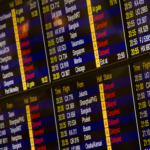 Close-up of digital flight information board showing arrivals and departures at an airport.