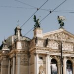 Lviv Theatre of Opera and Ballet under a sunny blue sky, showcasing intricate architecture.