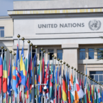 Colorful flags outside the United Nations office in Geneva, symbolizing global unity.