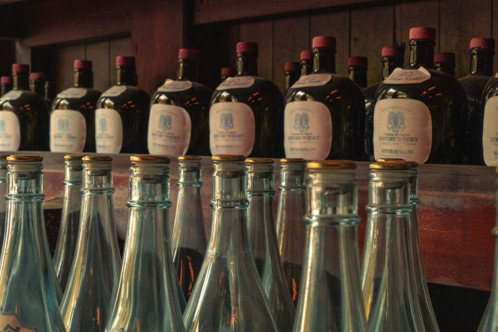 Rows of vintage whisky bottles create a warm, classic atmosphere in a Tokyo bar.