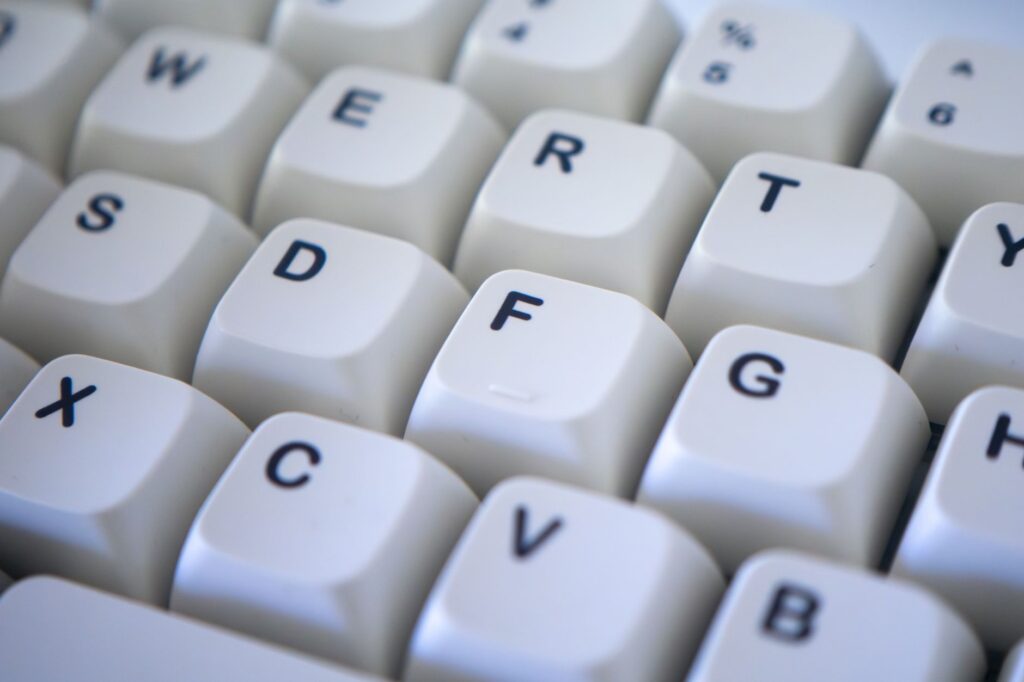 Detailed view of a white computer keyboard focusing on keys. Perfect for technology themes.