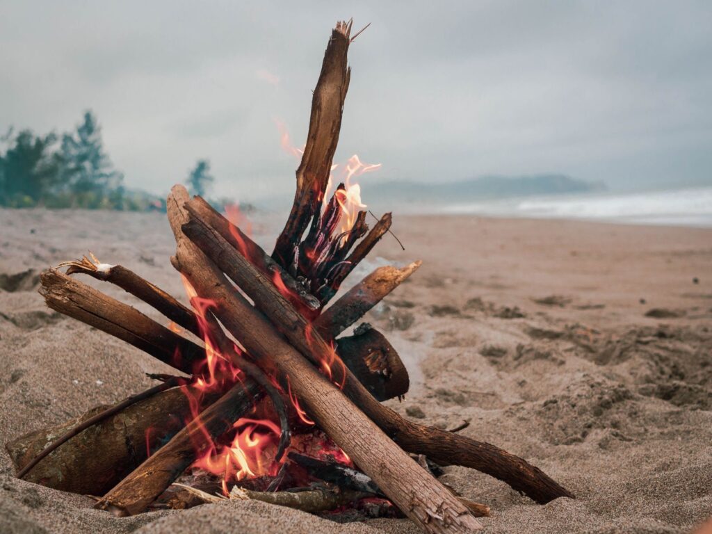 A cozy bonfire on a picturesque beach, perfect for a tranquil evening.