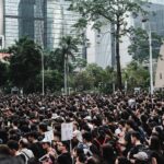 Massive crowd gathers during a protest in Hong Kong's urban district, showcasing urban activism.