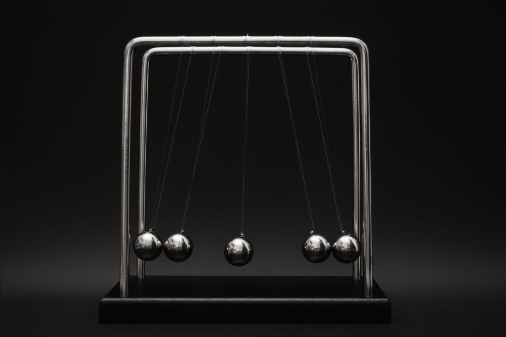 Newton's cradle for physics principles and motion study on a dark background.