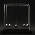 Newton's cradle for physics principles and motion study on a dark background.